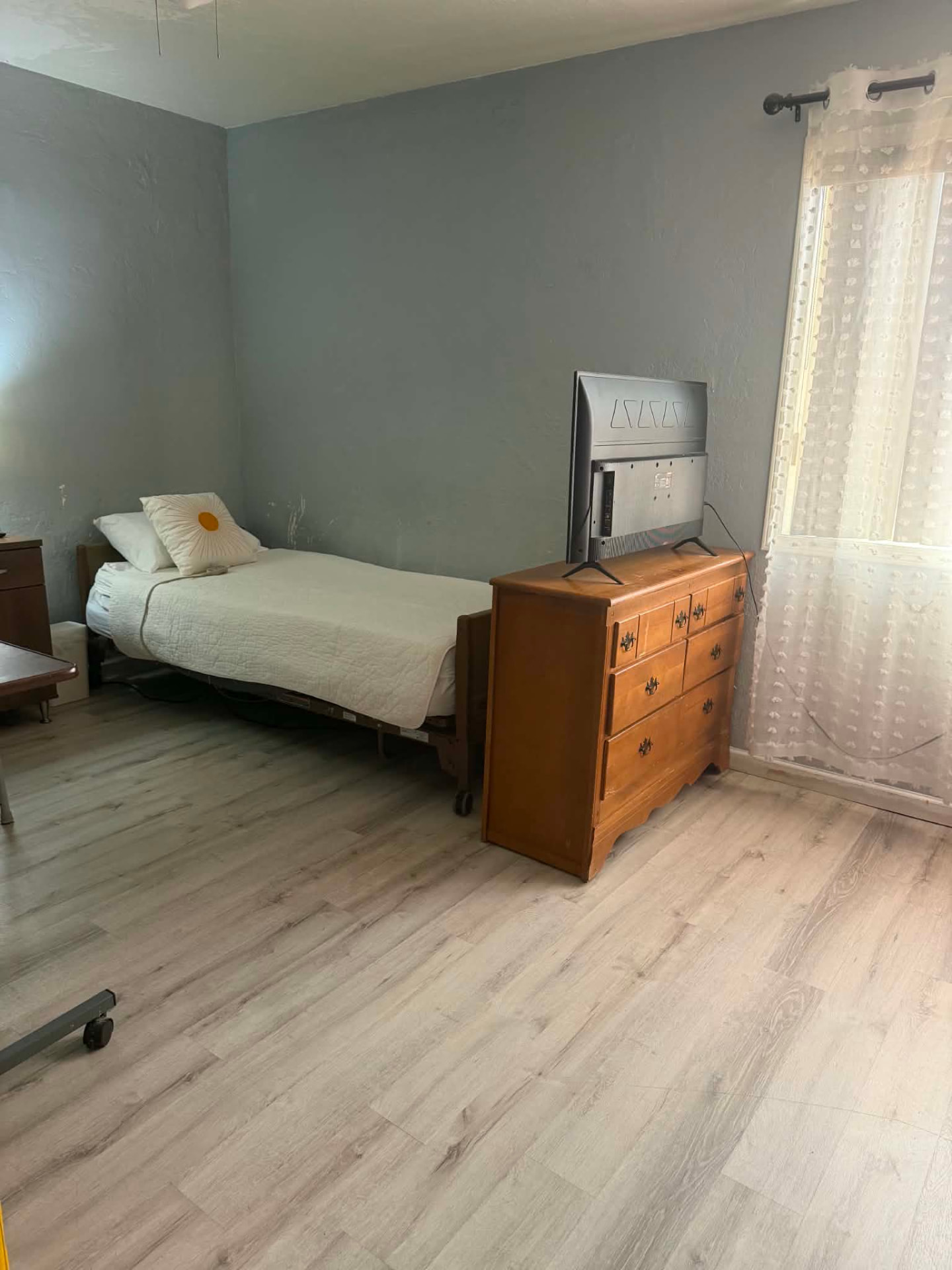 Spacious resident bedroom with dresser and natural light